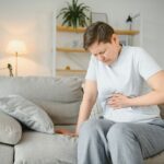 Sick upset middle aged lady hold belly suffer from abdomen ache concept