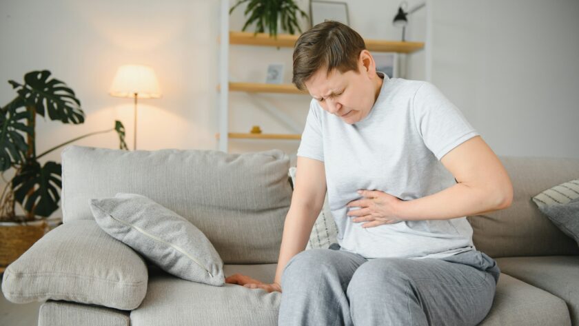 Sick upset middle aged lady hold belly suffer from abdomen ache concept
